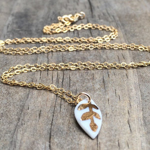 tiny white porcelain leaf gold glazed necklace, gold filigree jewelry, white and gold, Austin jewelry, porcelain wearable art, social impact jewelry, ethical accessory